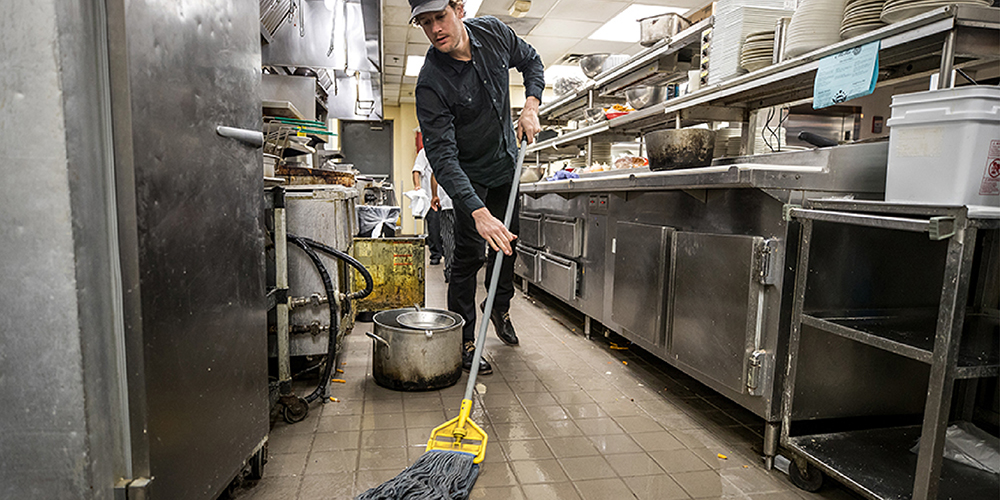 Worker mopping in kitchen